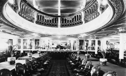 Salle dotée d’un mobilier luxueux et d’un plafond ouvragé avec une ouverture arrondie au centre bordée d’une balustrade.