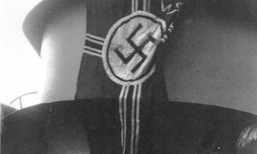 Flag bearing a swastika in a circle and a small Maltese cross in its upper left corner.