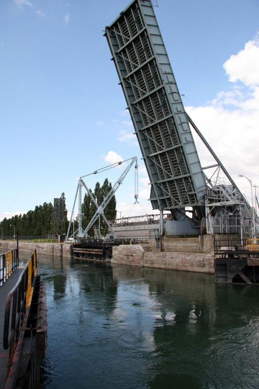 The gates of the lock are open. The bridge is fully raised and the water level in the chamber and in the canal is the same.