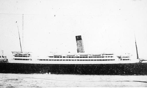 A ship with a single smoke stack. Its white decks stand out against its dark hull.