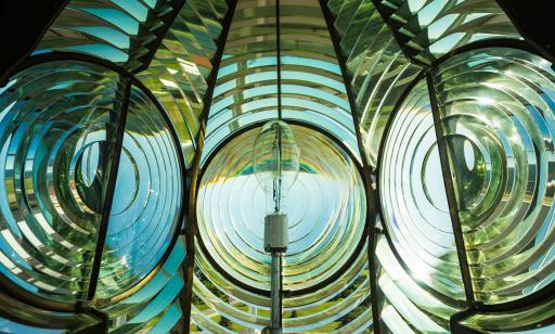 Close-up view of the inside of a lens, showing electric bulb and many rings carved into the glass.